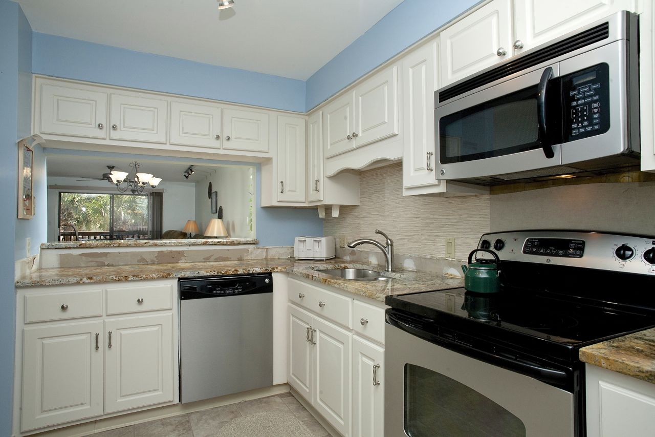 A kitchen with white cabinets, a microwave, a stove, and a dishwasher.
