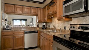 A kitchen with wooden cabinets, a dishwasher, a stove, and a microwave.