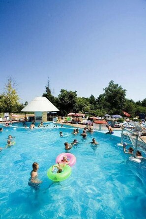 A large outdoor swimming pool with multiple people and inflatable rings. - Hotel Orchidea (Albena)