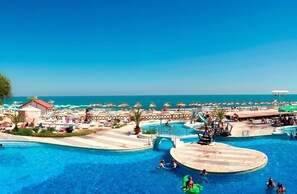 Un complexe hôtelier doté d’une grande piscine, de parasols de plage et offrant une vue sur l’océan.