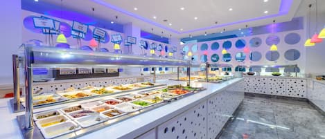 Un área de bufé con varias estaciones de comida, un diseño moderno de techo y un piso limpio y pulido.