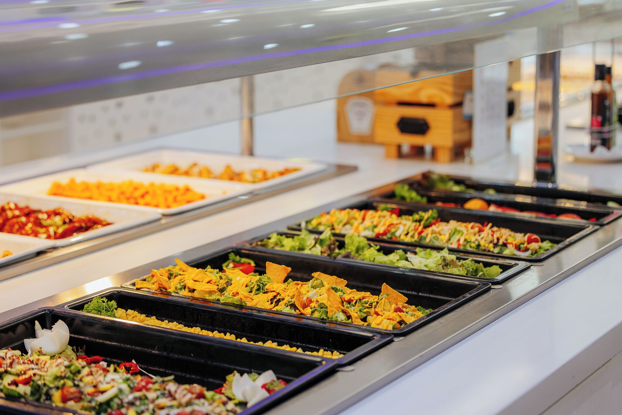 A buffet with various food options including salads, pasta, and other dishes.