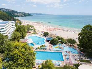 A resort with multiple swimming pools, a beach, and a view of the sea.