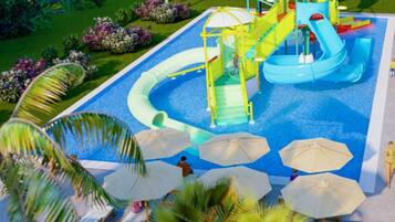 Ein Wasserpark mit Rutschen und Schwimmbecken, umgeben von Palmen und Sonnenschirmen.