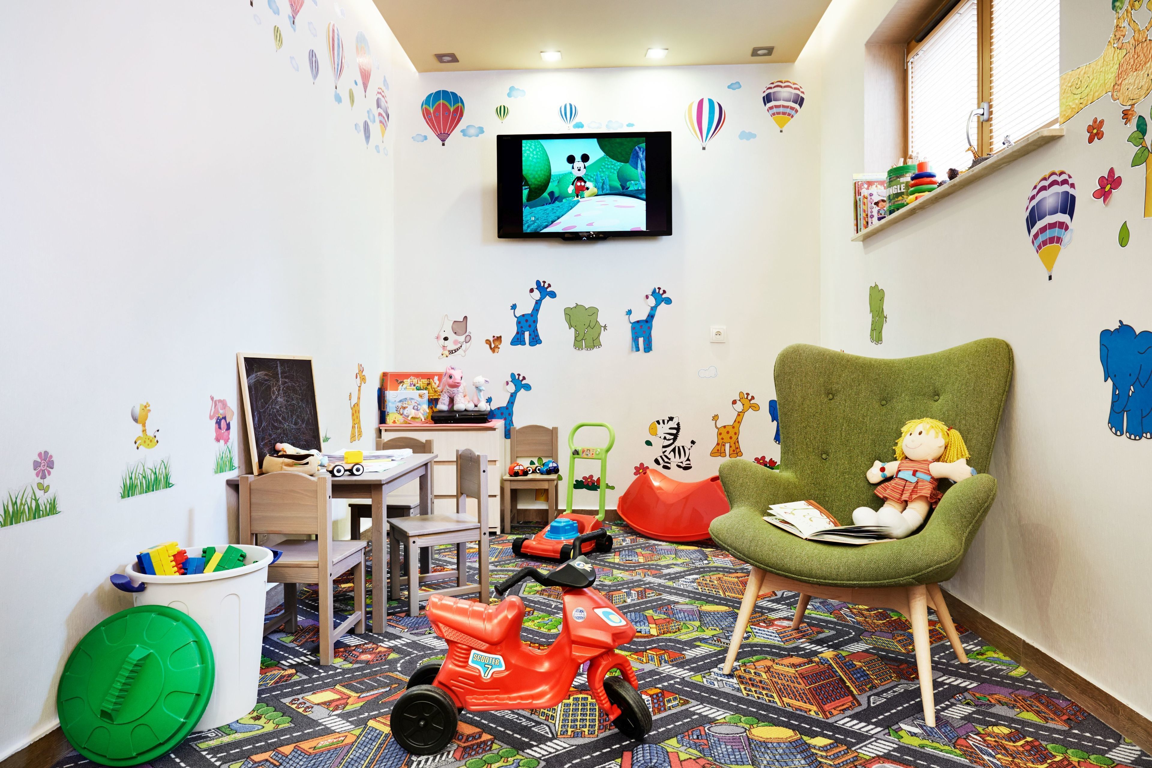 Ein Kinderzimmer mit Fernseher, Spielzeug und Lernmaterialien.