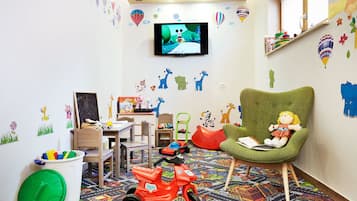 Ein Kinderzimmer mit Fernseher, Spielzeug und Lernmaterialien.
