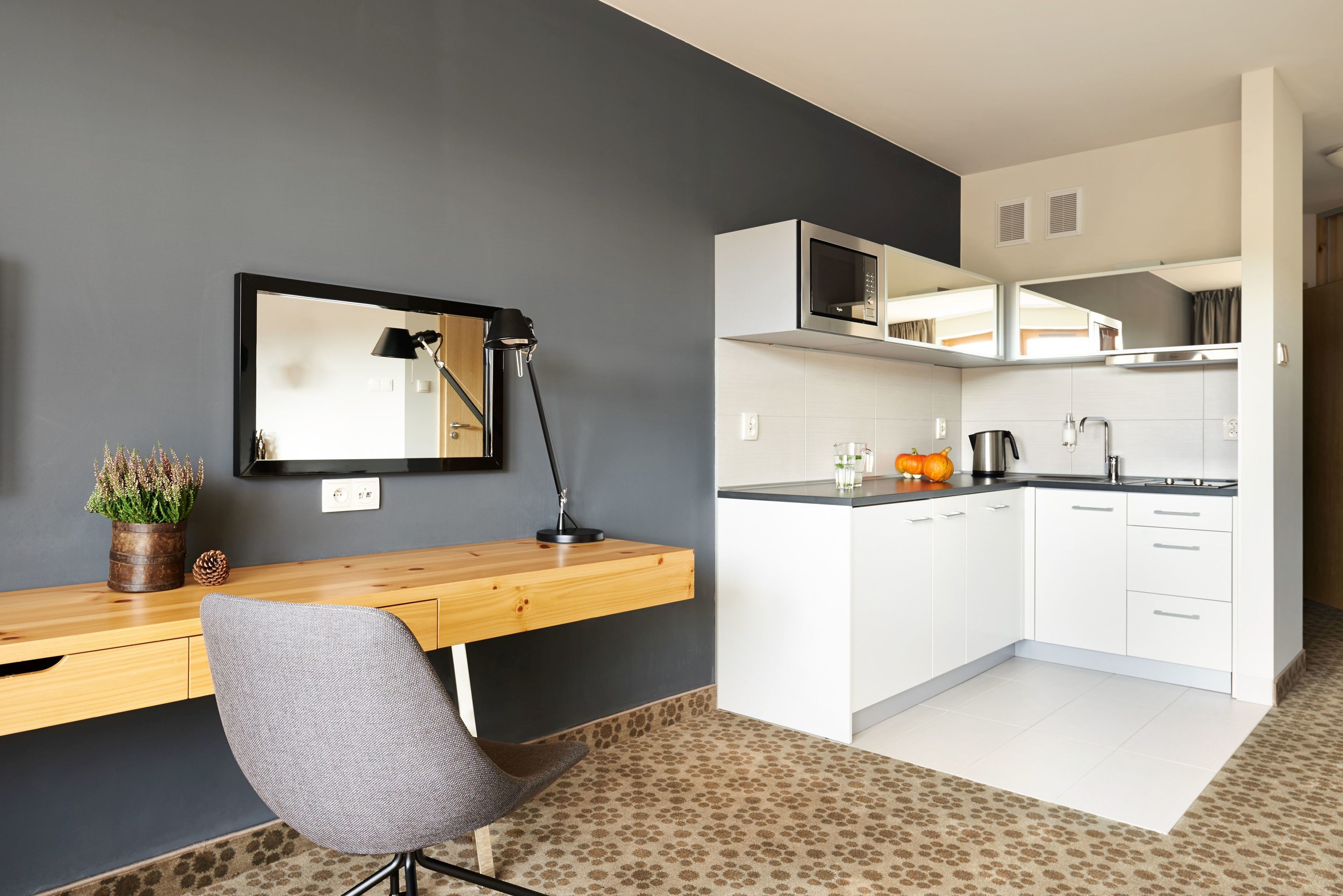 A compact kitchen with white cabinets, a microwave, and a coffee maker.