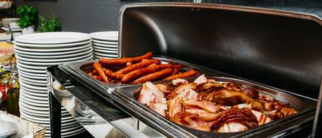 A buffet with various meats and sausages.