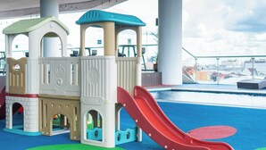 Un espace de jeux pour enfants avec un toboggan et une structure ressemblant à un château.