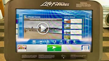 A Life Fitness exercise machine with a screen displaying workout options and a QR code.