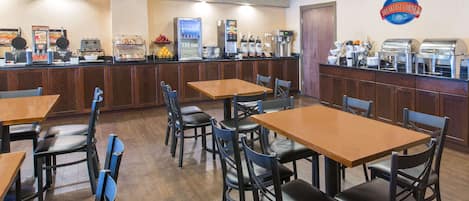 Rincón de desayuno con mostrador, asientos y diferentes opciones para el desayuno.