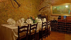 Un coin repas avec un mur en briques, un meuble à vin et un tableau encadré.