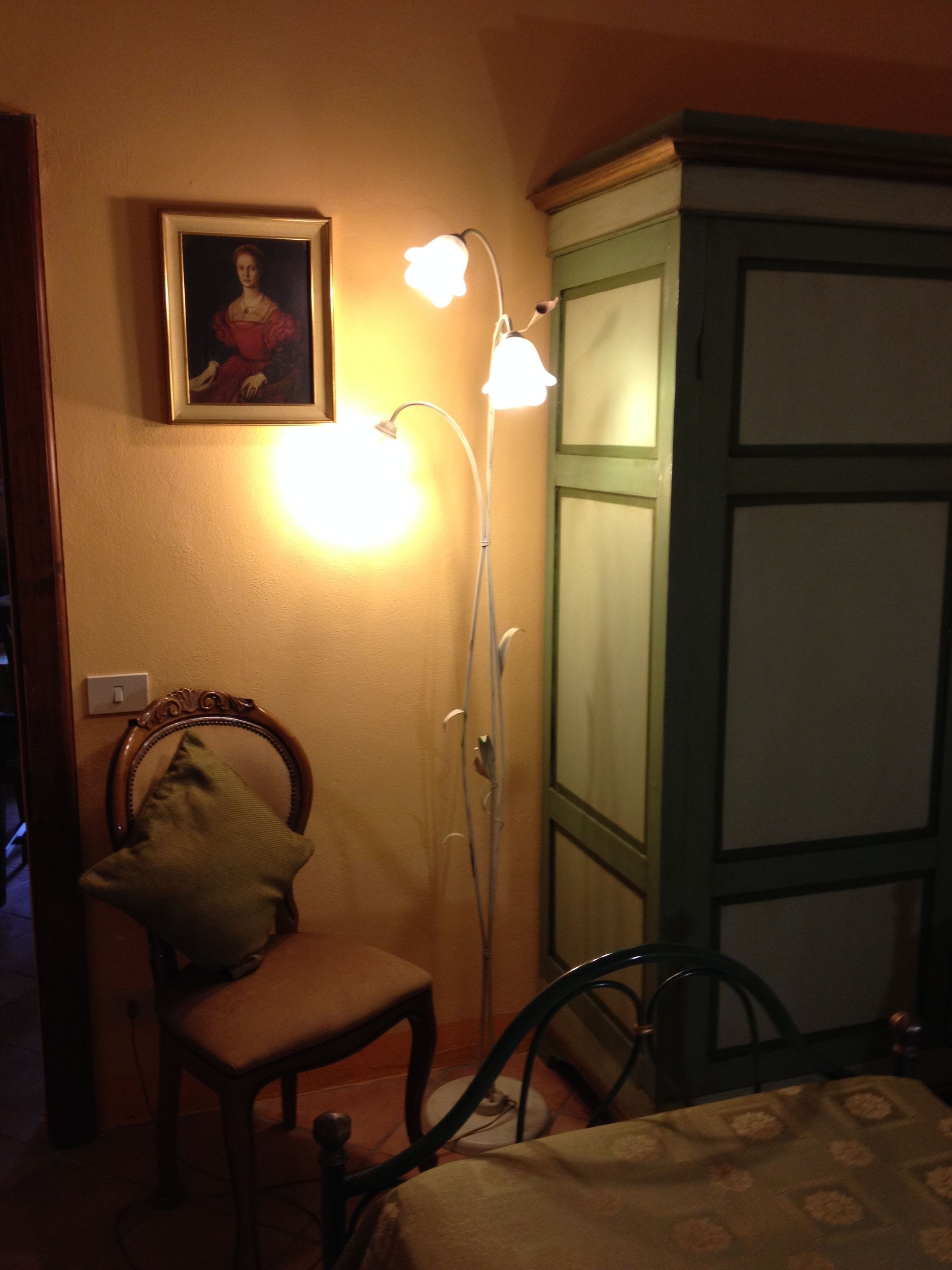 A room with a chair, a cabinet, and a wall-mounted light fixture.