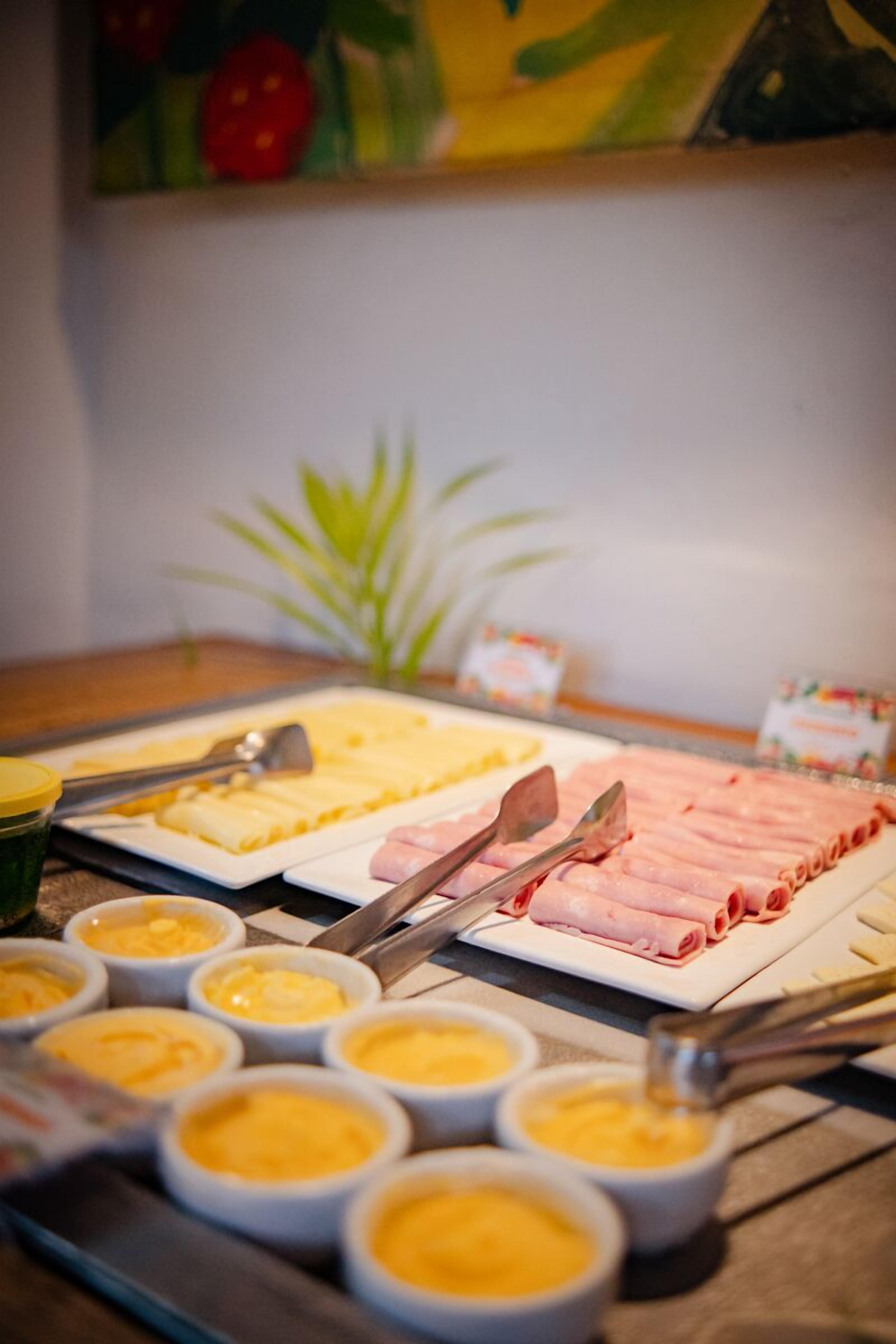 A buffet with various food items including sliced meats and cheese.