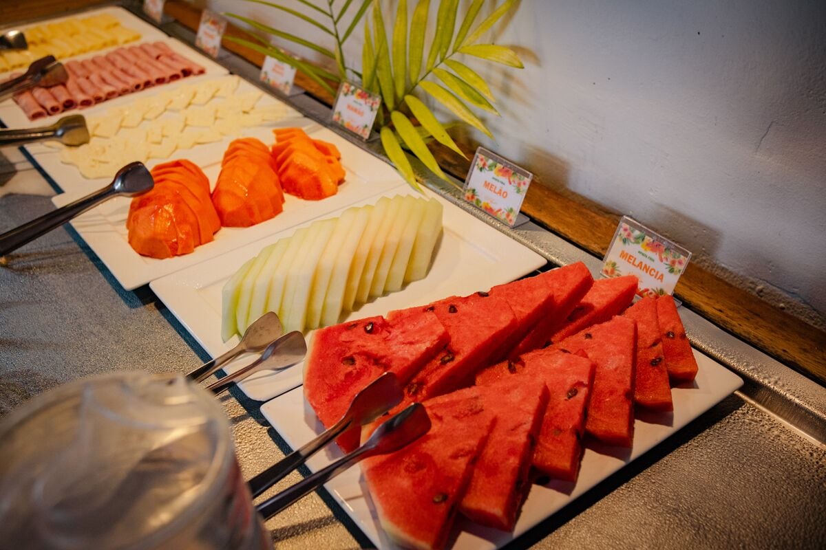 A buffet with various fruits and vegetables, including watermelon, carrots, and melon.