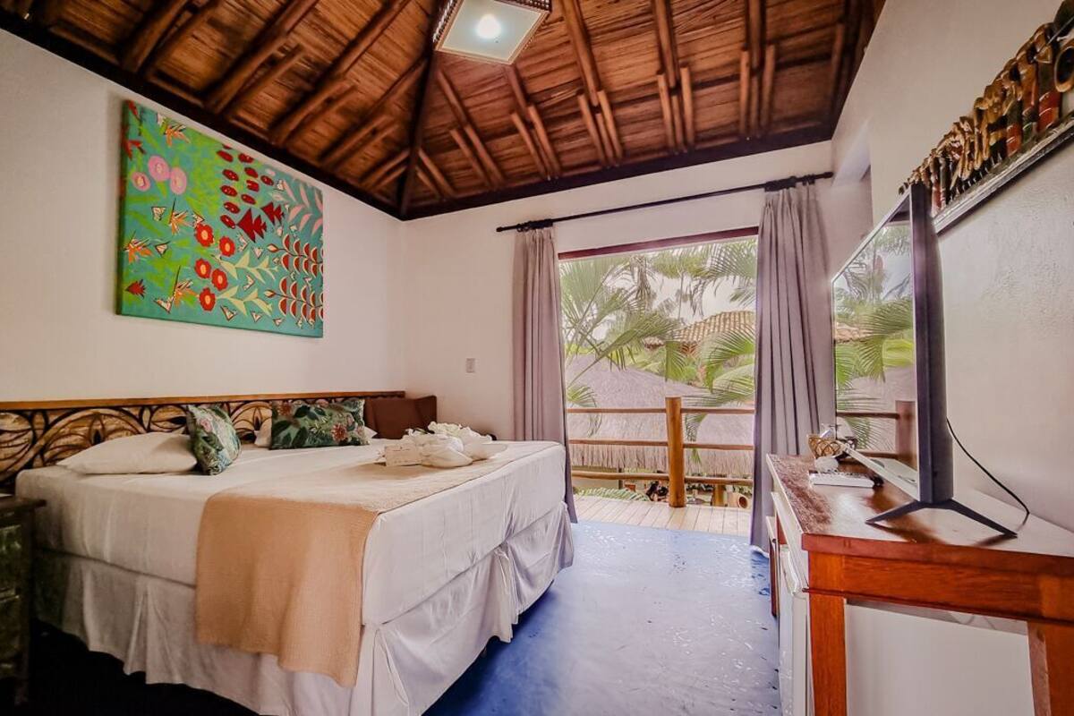 Una camera da letto con un letto, una scrivania, un quadro e vista sull'esterno.