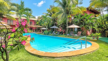 Una piscina al aire libre, sillones reclinables de piscina