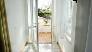 A hallway leading to an outdoor patio with a table and chairs. - La Casa di Carla (Ravello)