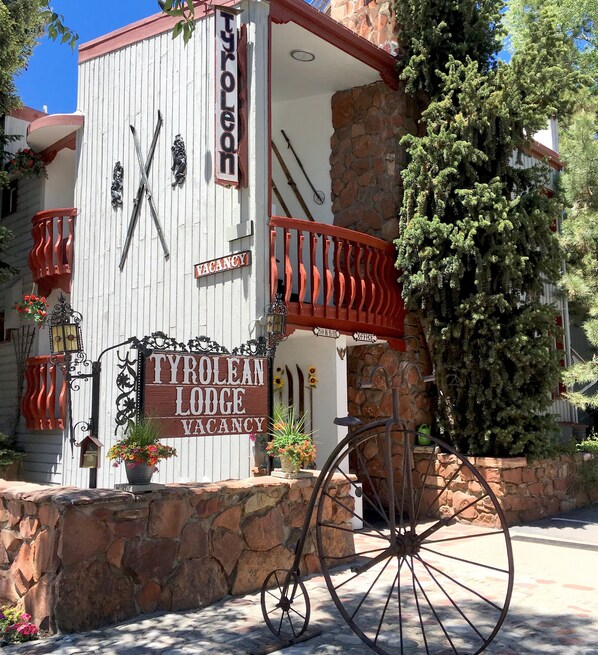 A wooden building with a sign indicating a vacancy at the Tyrolean Lodge.