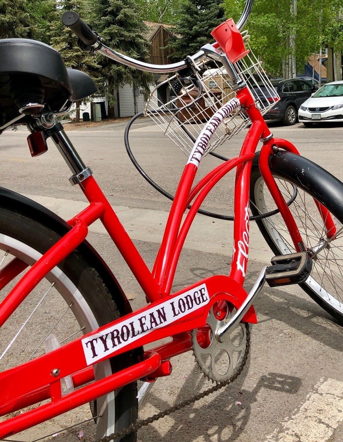 Una bicicleta roja con una cesta y un cartel que dice "TYROLEAF LODGE".