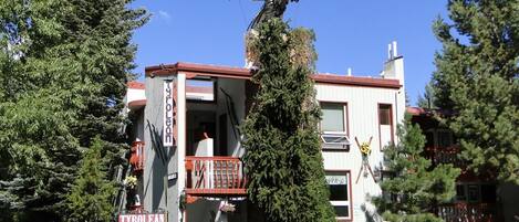 A lodge with a balcony, a bird sculpture, and a sign indicating vacancy.