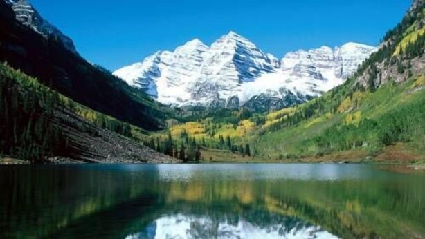 Un lago de montaña con reflejos nítidos de las cumbres.