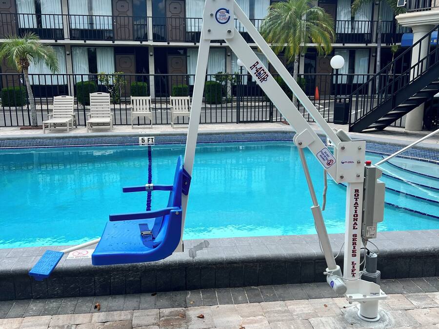 Una piscina al aire libre, sillones reclinables de piscina