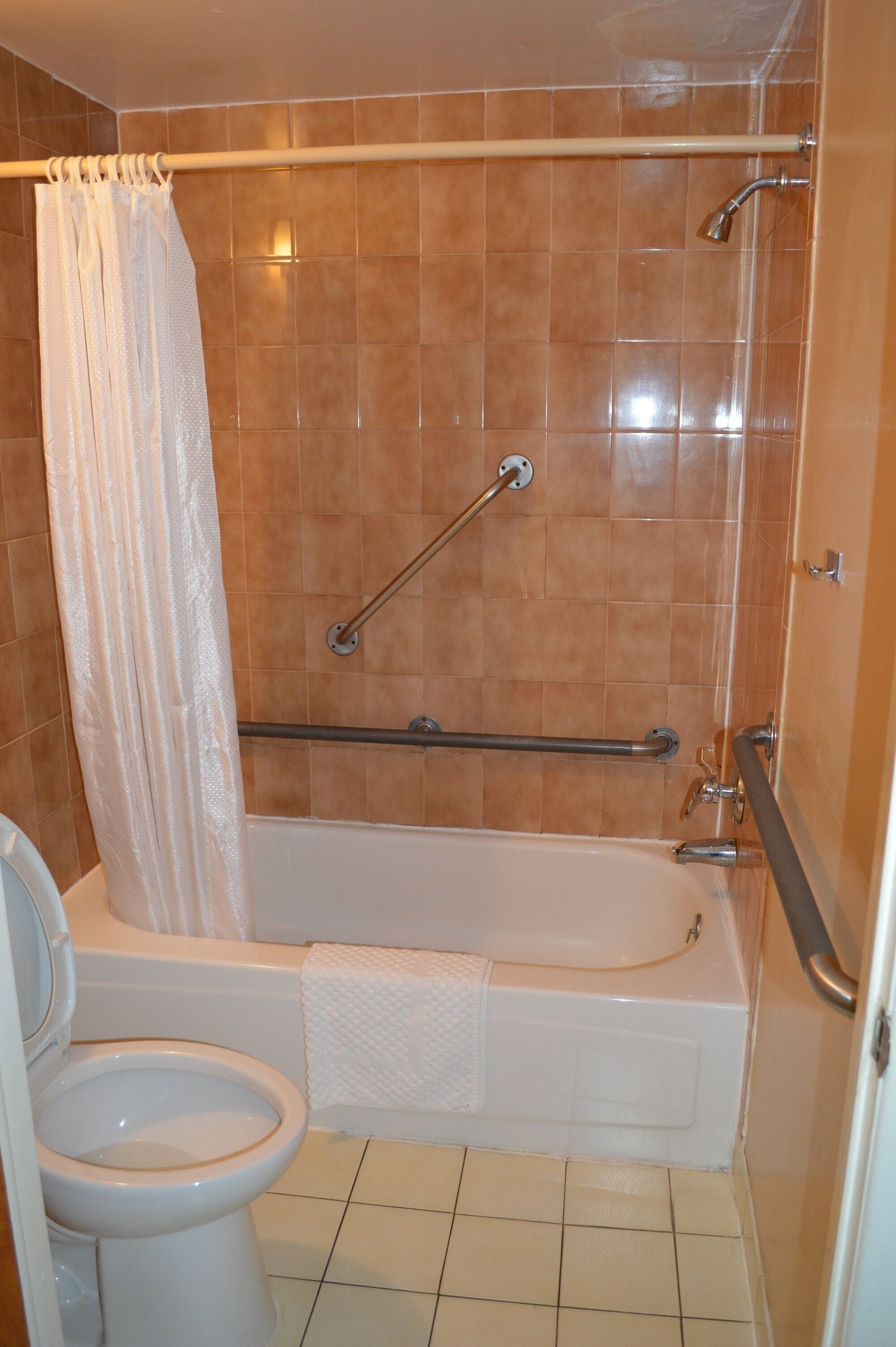 Een badkamer met een bad, douche en toilet.
