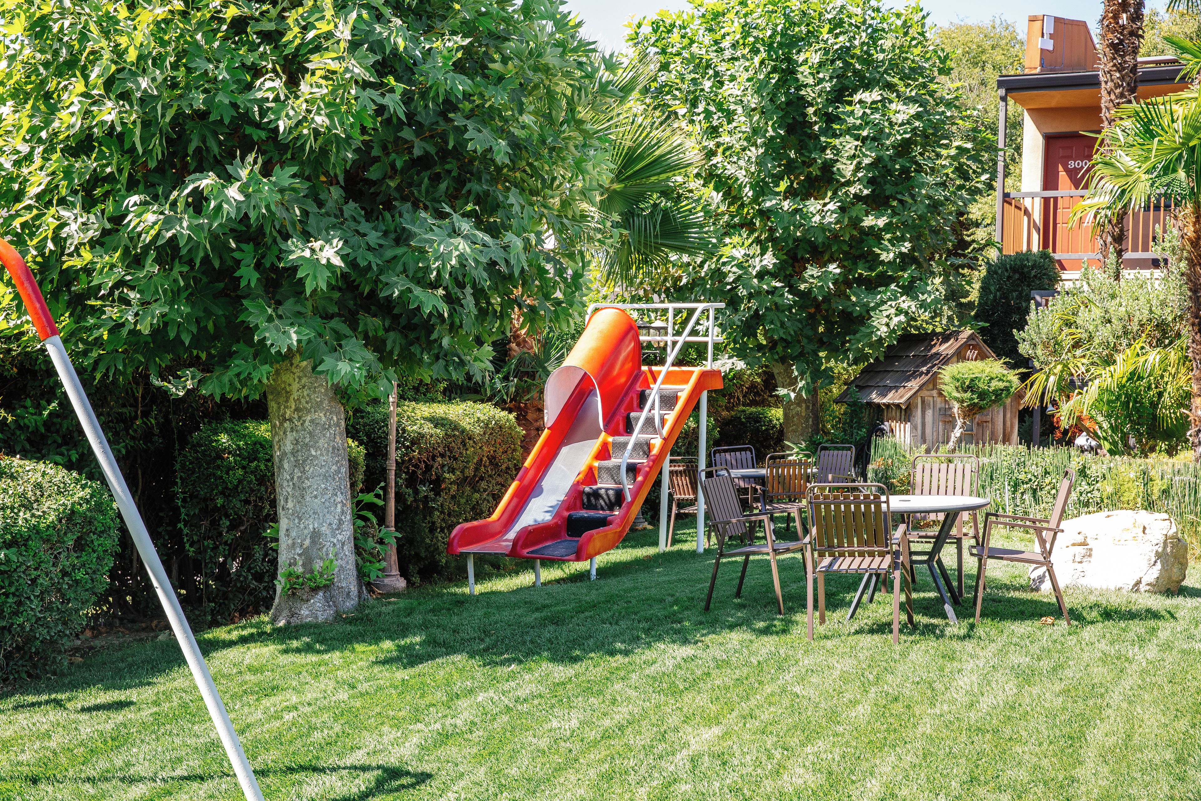 A playground with a slide and a picnic table with chairs.