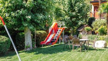 A playground with a slide and a picnic table with chairs.