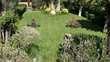 A well-maintained lawn with picnic tables and a clear view of a building in the background.