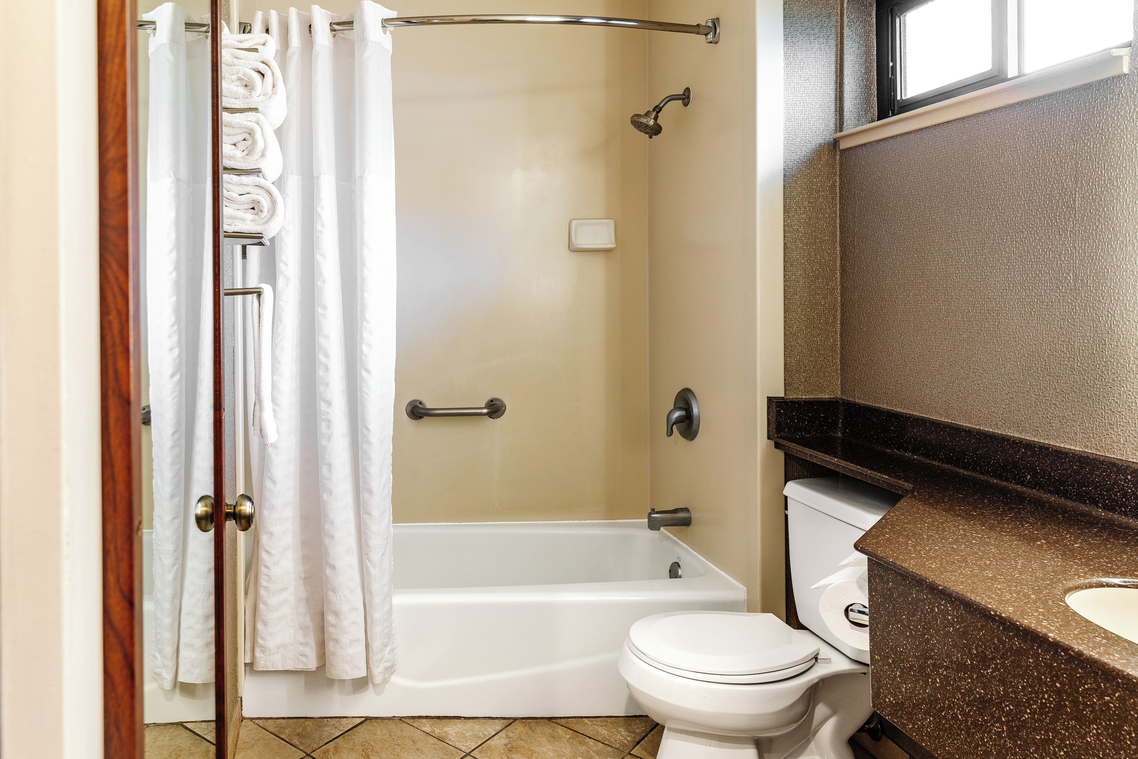 A bathroom with a shower, toilet, and a sink.
