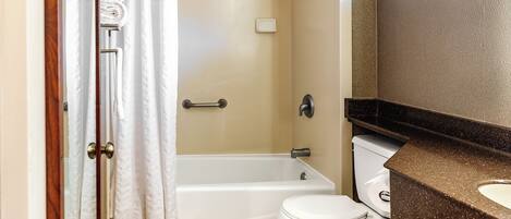 A bathroom with a shower, toilet, and a sink.