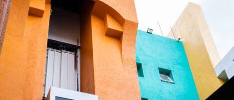 Un edificio con un diseño arquitectónico único que destaca por un arco prominente y una ventana.