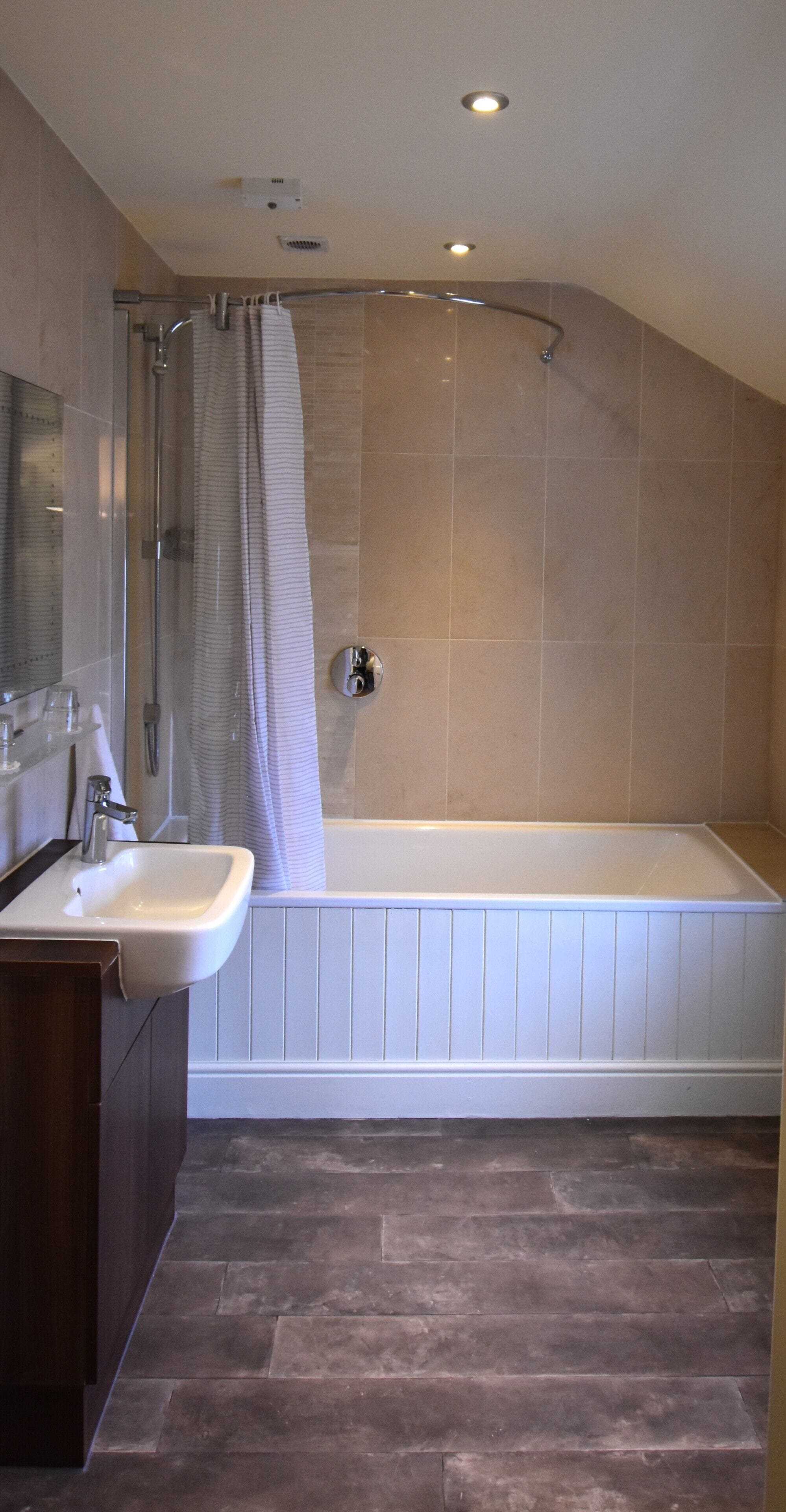 Un bagno moderno con doccia, lavabo e vasca da bagno.