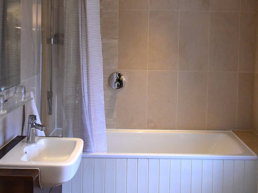 A modern bathroom with a shower, a sink, and a bathtub.