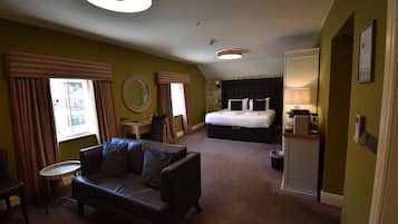 Una habitación de hotel con una cama, un sofá, una mesita y una silla.