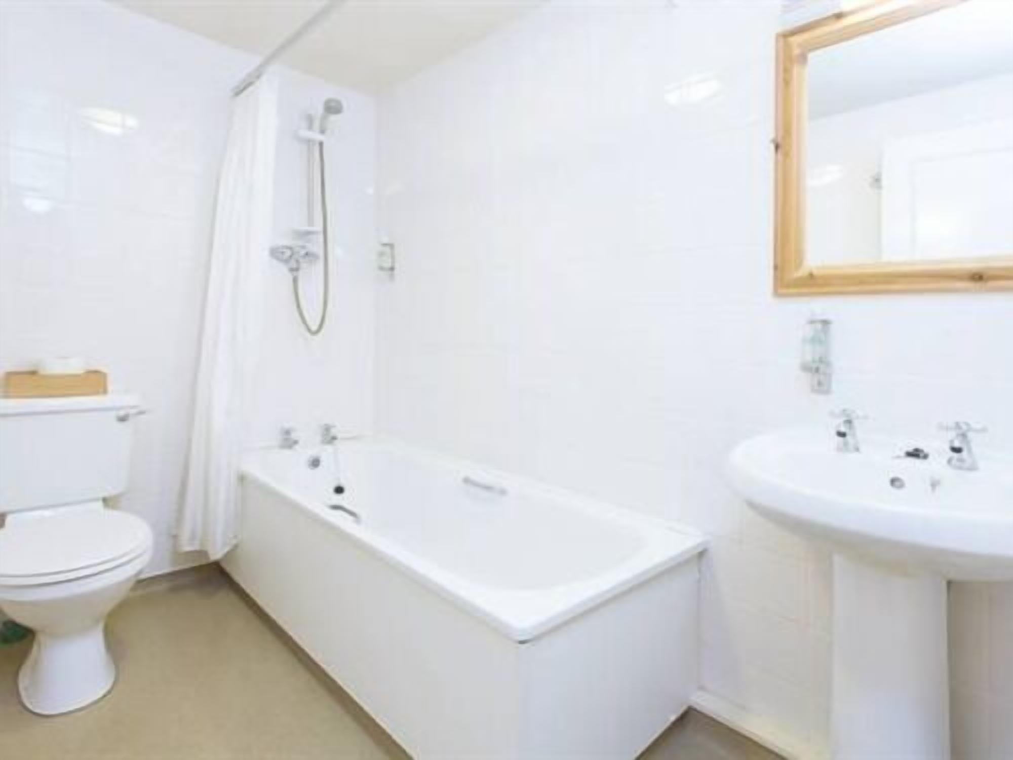 A bathroom with a toilet, a bathtub, and a sink.