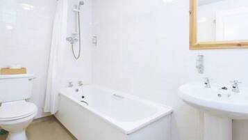 A bathroom with a toilet, a bathtub, and a sink.