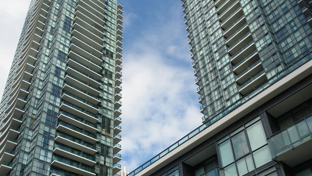 Un edificio moderno de gran altura con fachada de vidrio y varios balcones.