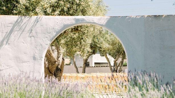 An arched structure with a view of trees and chairs. - Hacienda de Leal,  BW Signature Collection (San Juan Bautista)