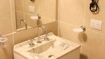A bathroom with a sink, mirror, and towel rack.