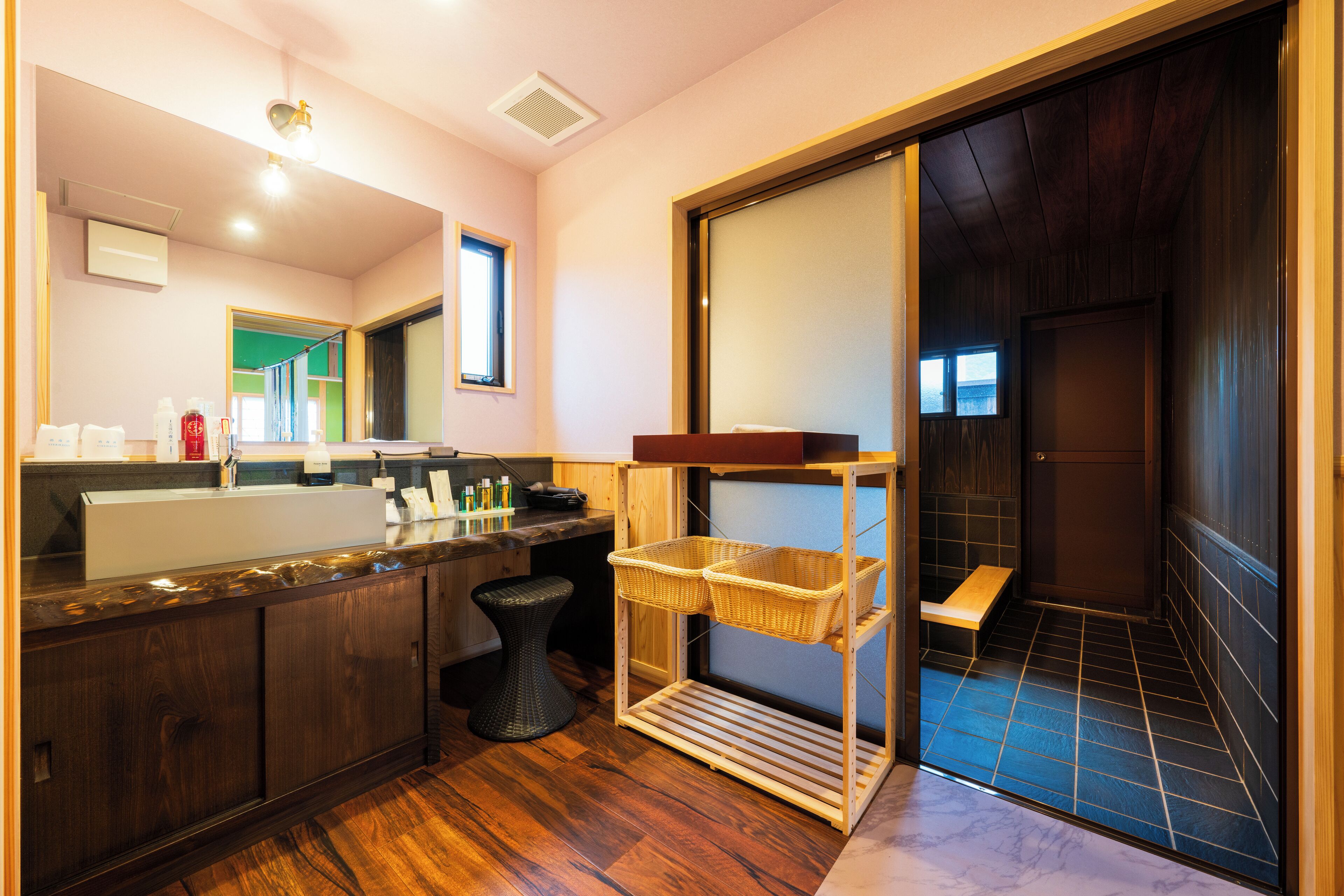 Een moderne badkamer met een houten wastafelmeubel, een grote spiegel en een douchegedeelte.