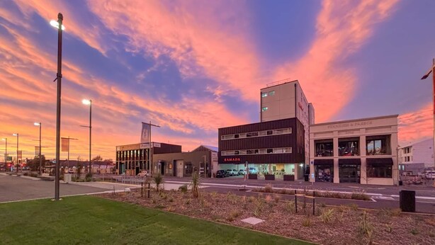 A modern building with a flat roof, large windows, and a sign that reads 'RAMADA.' - Ramada Suites by Wyndham Christchurch City (Christchurch)