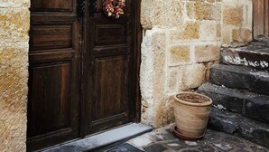 A stone building with a wooden double door, a number '7' sign, and a sign for 'Cave Konak'. - Has Cave Konak (Ürgüp)