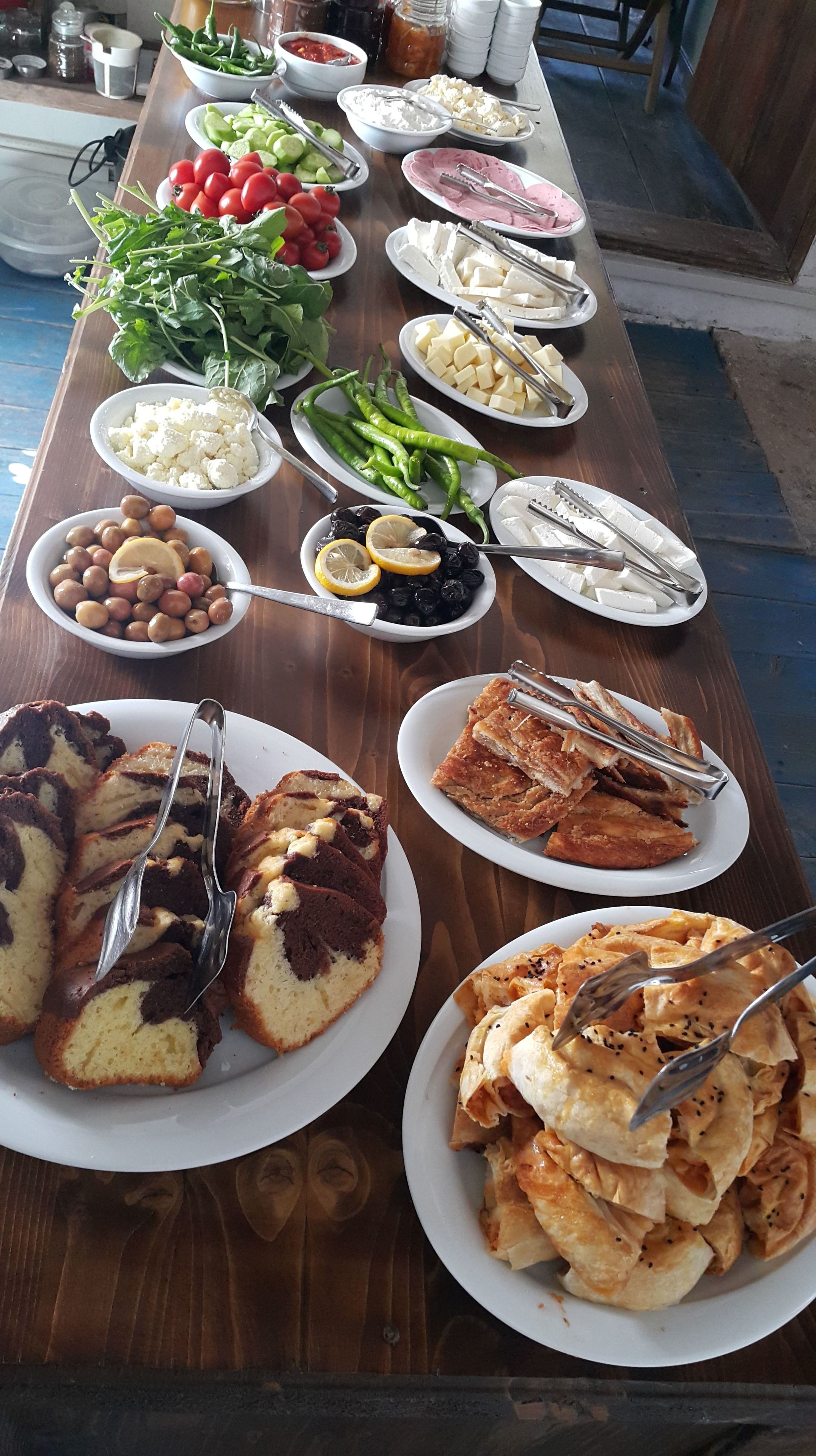 A buffet table with various food items including fruits, cheeses, and pastries.