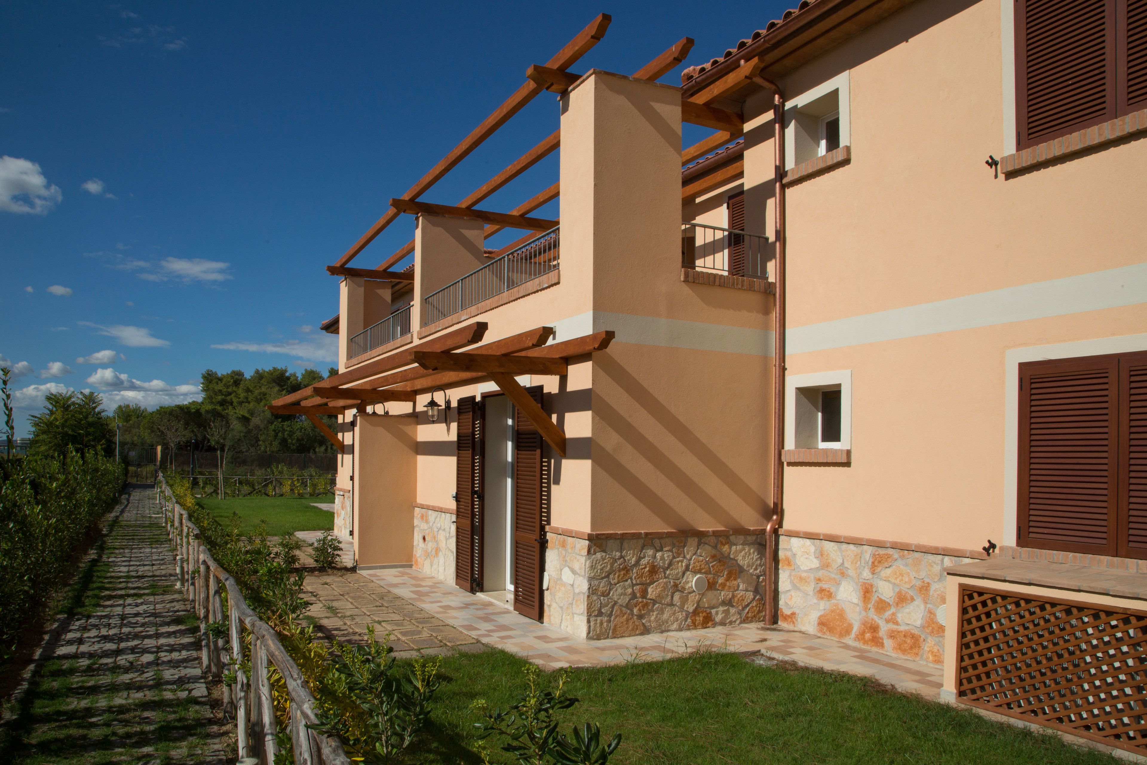 Edificio de dos pisos con base de piedra y barandillas de madera en el balcón.