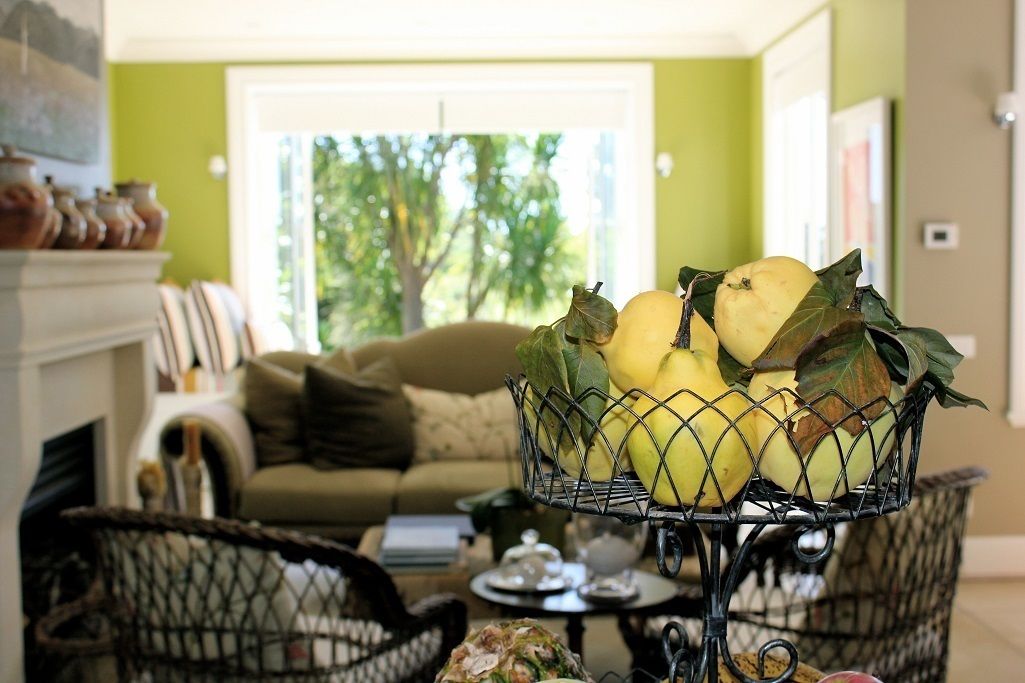 A living room with a sofa, a coffee table, and a decorative basket with yellow fruits and leaves.