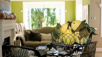 A living room with a sofa, a coffee table, and a decorative basket with yellow fruits and leaves.