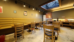 A restaurant interior with wooden booths and tables, a skylight, and a self-service counter.